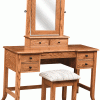 A wooden table with a stool, drawers, and a mirror